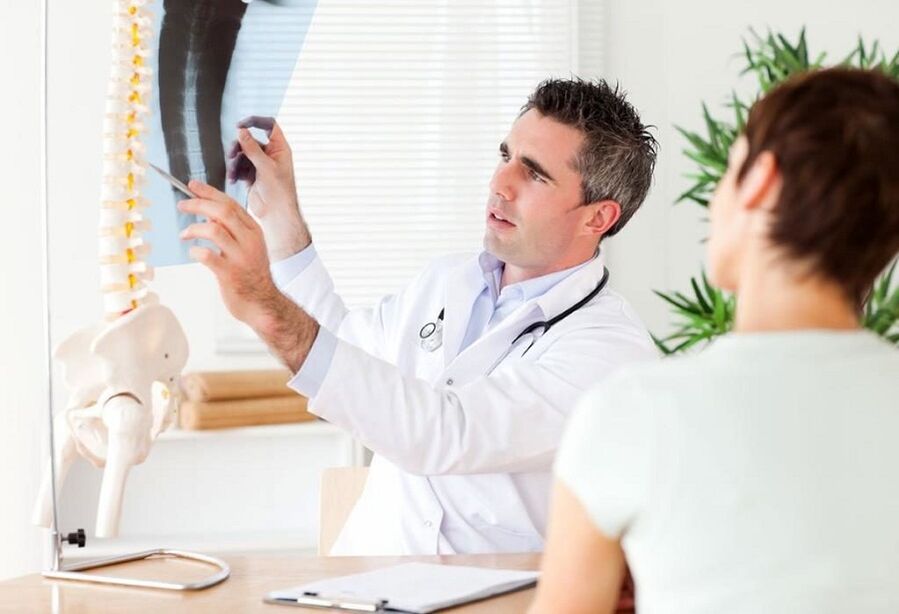 O médico examina unha radiografía para diagnosticar a osteocondrose torácica